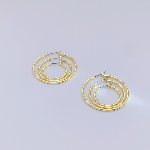 A set of three pairs of chunky gold hoop earrings in different sizes