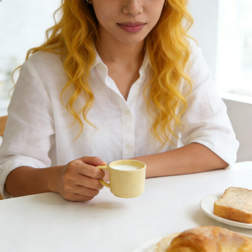 A set of four small ceramic cups in pastel shades of yellow, blue, green and pink.