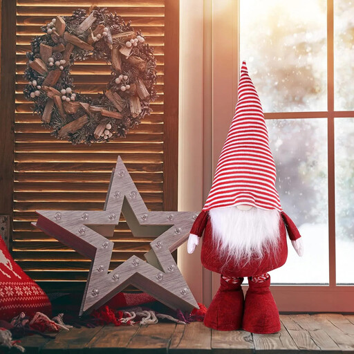 Ein großer Weihnachtswichtel mit roter Mütze und grauem Körper, dessen Beine teleskopisch ausfahrbar sind.