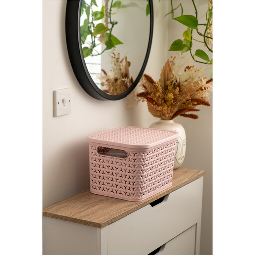 A blush pink woven-style plastic storage basket with a matching lid, shown on a white background.