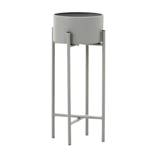A grey, round planter sits on a slim, black metal stand with crossed legs.